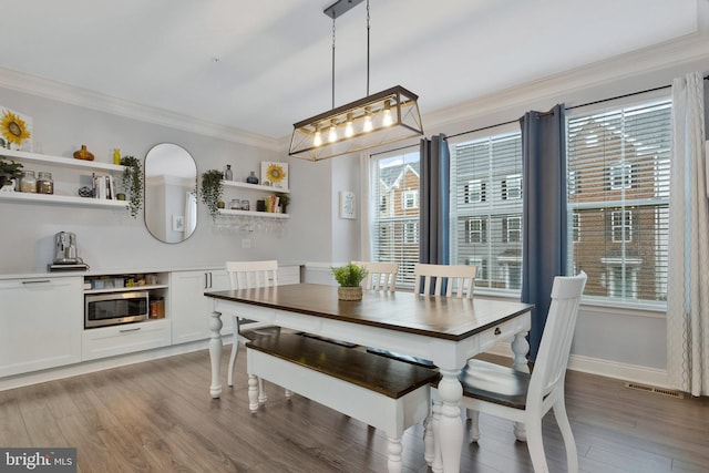 dining area with crown molding and dark hardwood / wood-style flooring