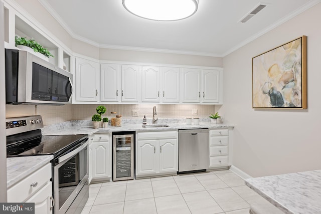 kitchen with sink, stainless steel appliances, wine cooler, light stone countertops, and white cabinets