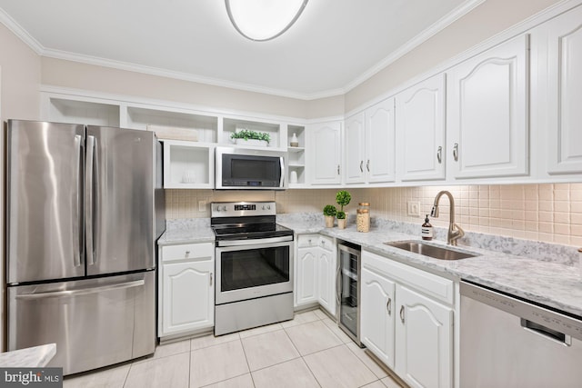 kitchen with appliances with stainless steel finishes, beverage cooler, sink, and white cabinets