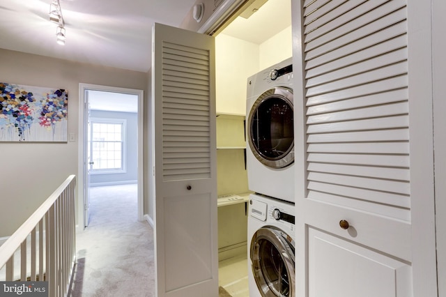 laundry room featuring light carpet and stacked washer / drying machine