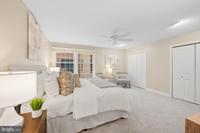 carpeted bedroom with multiple closets and ceiling fan