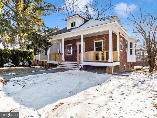 bungalow-style home with brick siding and a porch