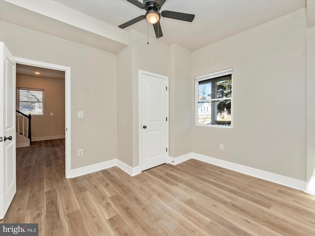 unfurnished bedroom with multiple windows, ceiling fan, and light hardwood / wood-style flooring