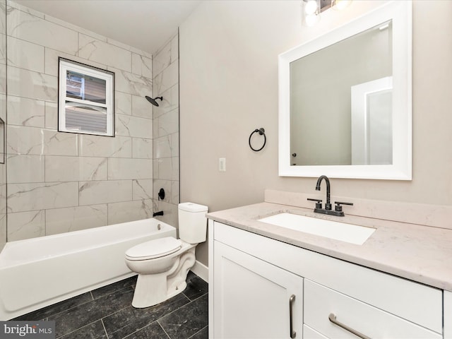 full bathroom with tile patterned flooring, tiled shower / bath, vanity, and toilet