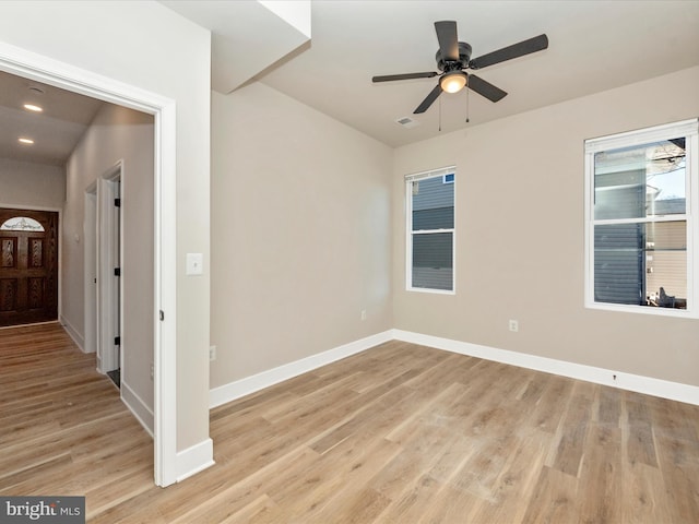 spare room with ceiling fan and light wood-type flooring