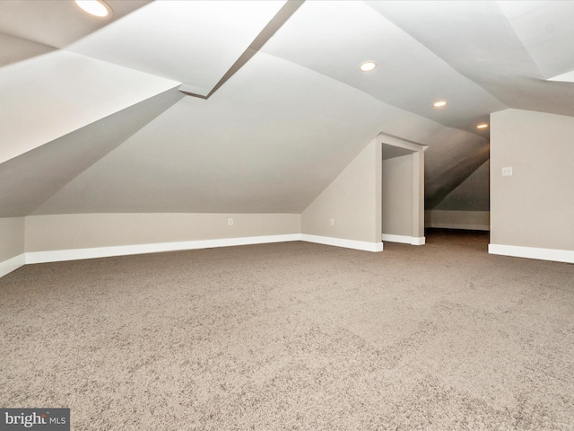 additional living space with vaulted ceiling and carpet