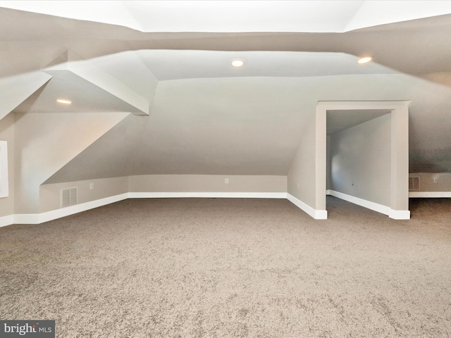 additional living space with vaulted ceiling and carpet