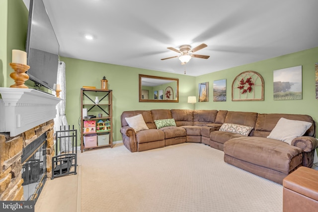 living room with ceiling fan, carpet, and a fireplace