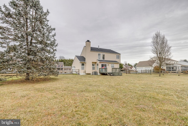 back of property featuring a wooden deck and a yard