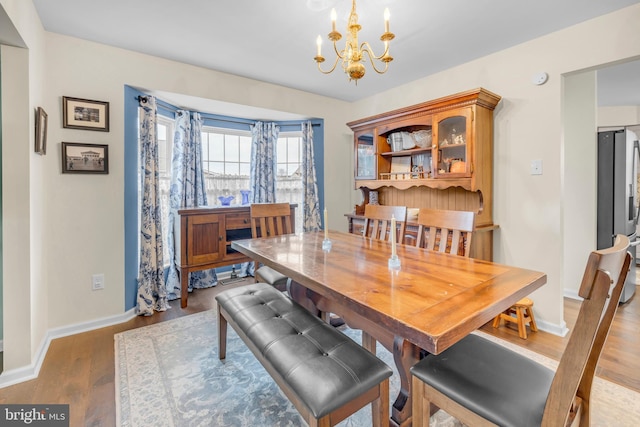 dining area with light hardwood / wood-style floors and a chandelier