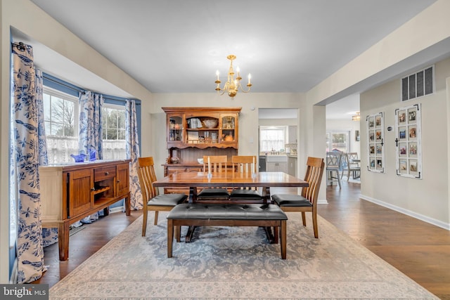 dining area with wood-type flooring and a chandelier