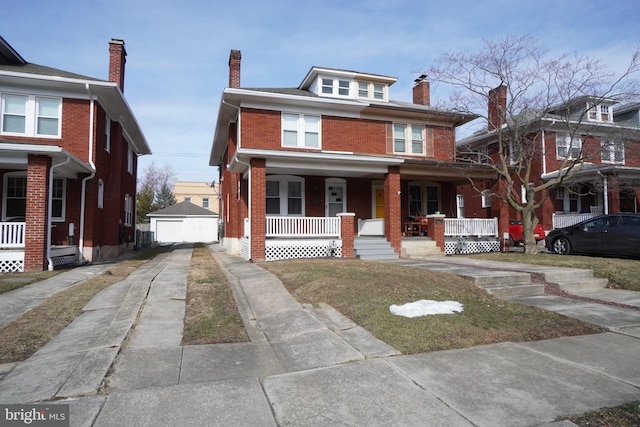 view of front of property with a garage, an outdoor structure, and covered porch