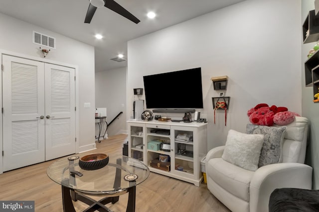 living room with ceiling fan and light hardwood / wood-style flooring