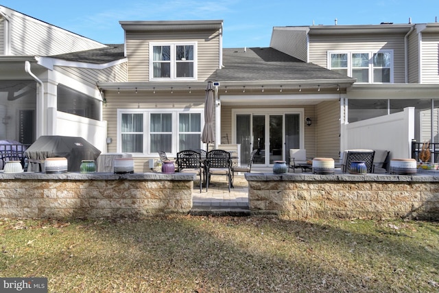 rear view of property with a patio and a lawn