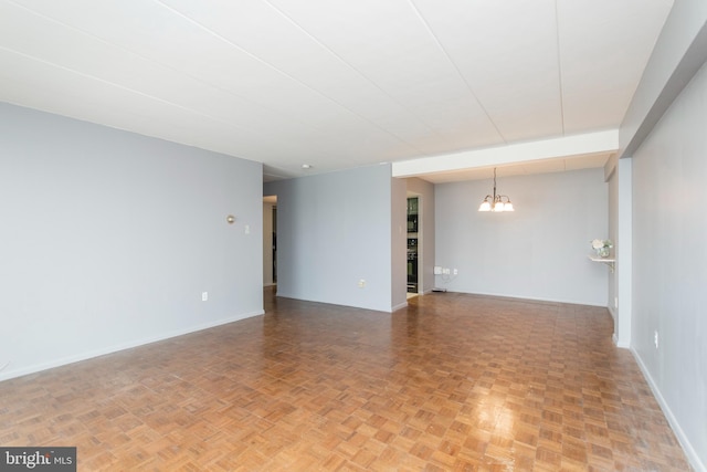 unfurnished room with parquet floors and a notable chandelier