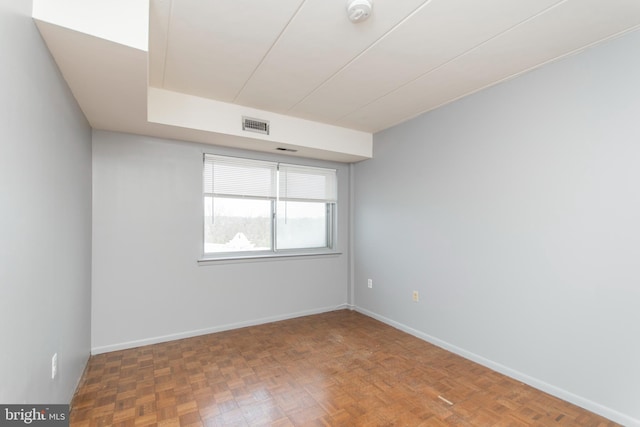 spare room featuring parquet flooring