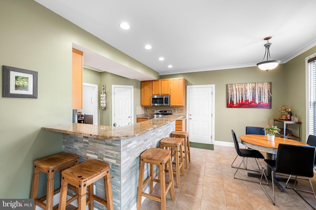 kitchen featuring a breakfast bar, kitchen peninsula, pendant lighting, stainless steel appliances, and decorative backsplash