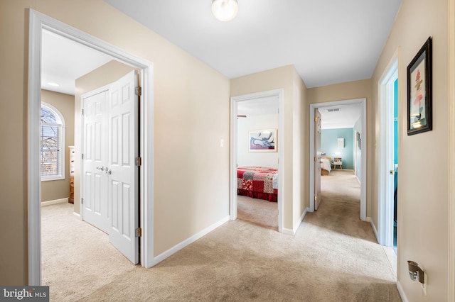 hall featuring light colored carpet