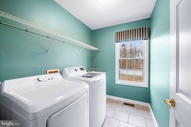 clothes washing area featuring light tile patterned flooring and washing machine and clothes dryer