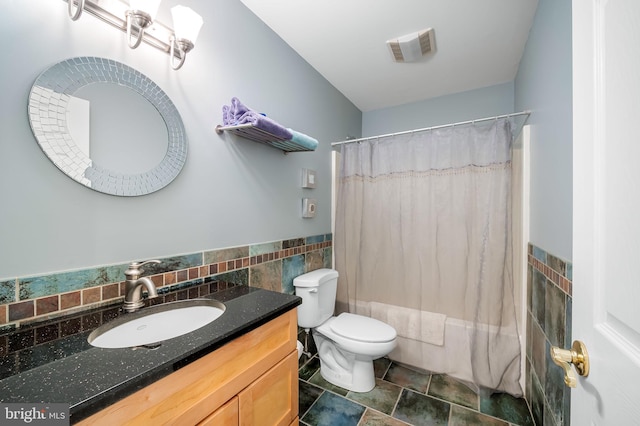 full bathroom with vanity, tile walls, shower / tub combo with curtain, and toilet