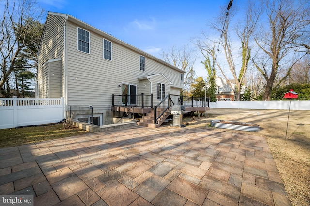 back of house featuring a deck and a patio area