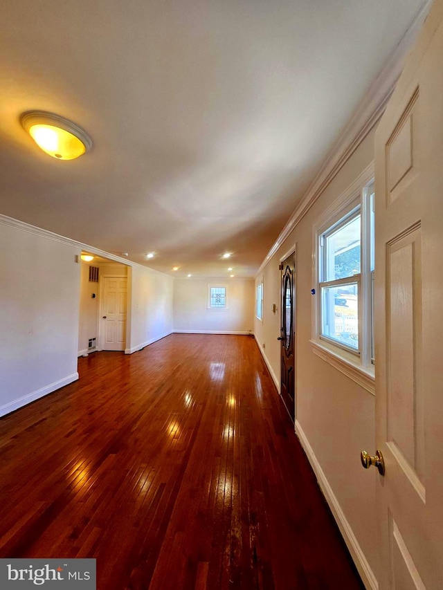 spare room with dark hardwood / wood-style flooring and crown molding