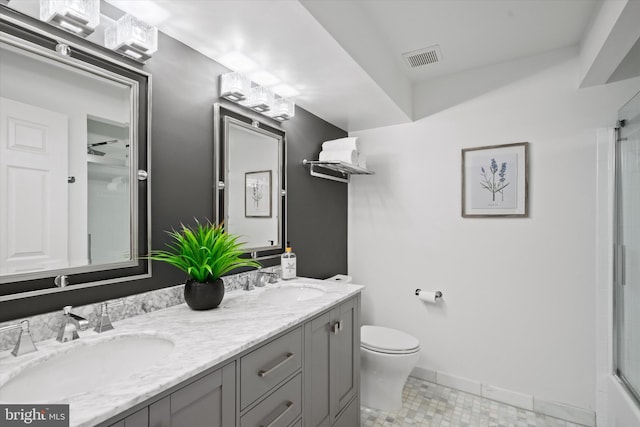 full bathroom featuring enclosed tub / shower combo, vanity, and toilet