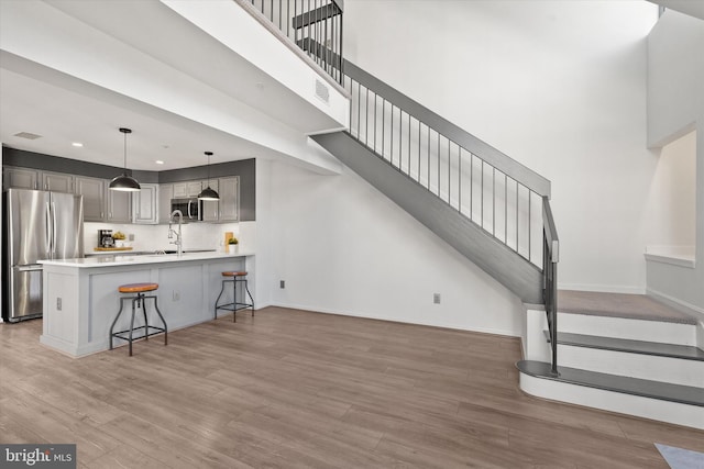 interior space with wood-type flooring, a towering ceiling, and sink