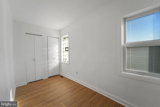 unfurnished bedroom featuring hardwood / wood-style floors and a closet