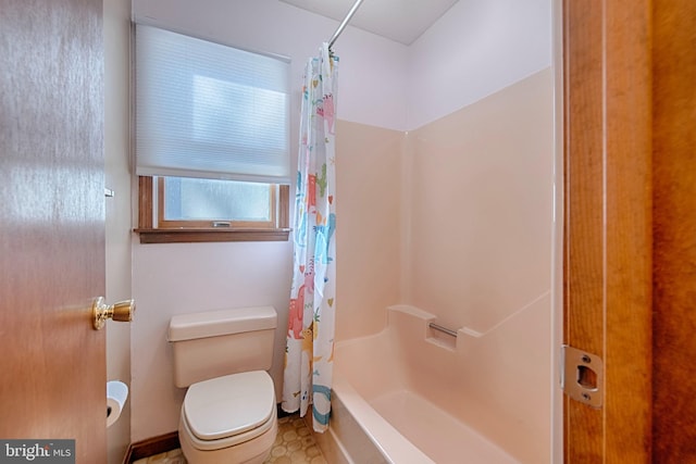 bathroom featuring shower / tub combo and toilet