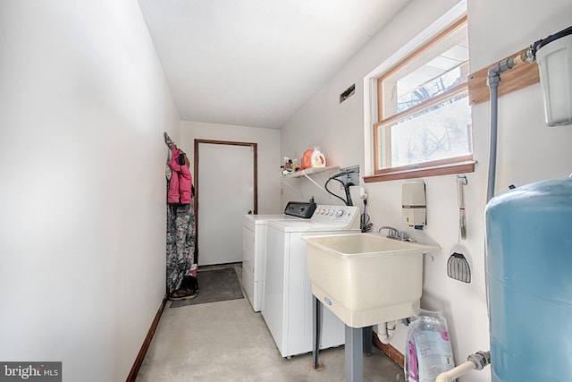 laundry area with separate washer and dryer and sink