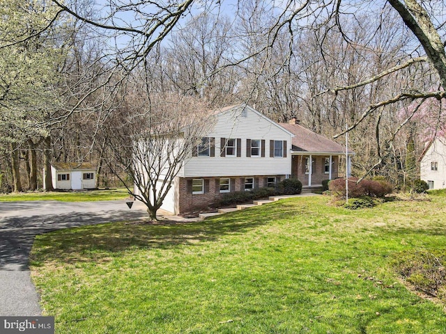 tri-level home featuring an outbuilding and a front yard