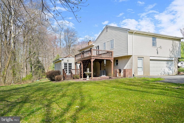 back of property featuring a garage, a deck, central AC unit, and a lawn