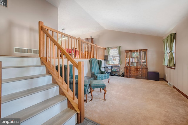 staircase featuring carpet flooring and vaulted ceiling