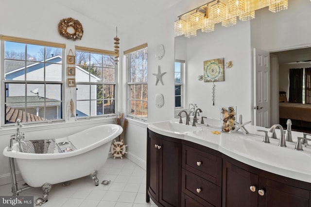 bathroom featuring an inviting chandelier, vanity, tile patterned flooring, and a tub