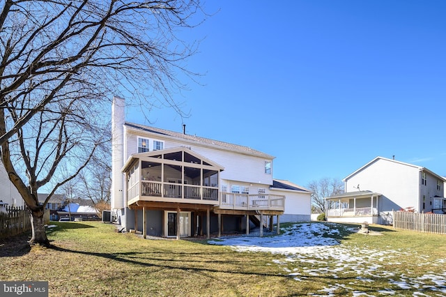 rear view of property with a wooden deck, a sunroom, a yard, and central AC