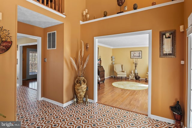 interior space with crown molding and light tile patterned flooring