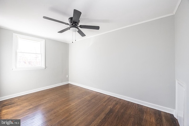 empty room featuring ornamental molding, dark wood-type flooring, and ceiling fan