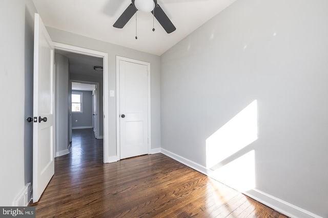 unfurnished room featuring dark wood-type flooring and ceiling fan