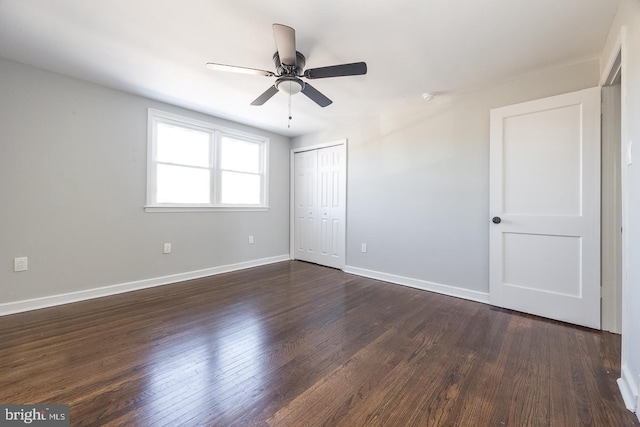 unfurnished bedroom with ceiling fan, dark hardwood / wood-style flooring, and a closet