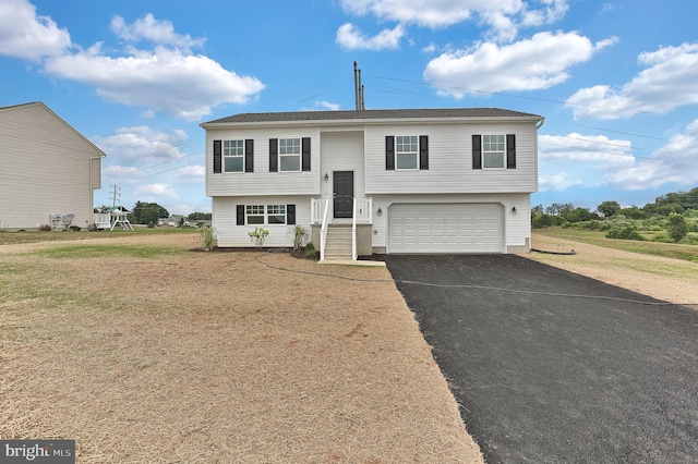 split foyer home featuring a garage and a front lawn