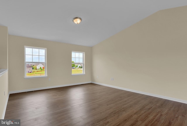 spare room with lofted ceiling and dark hardwood / wood-style flooring