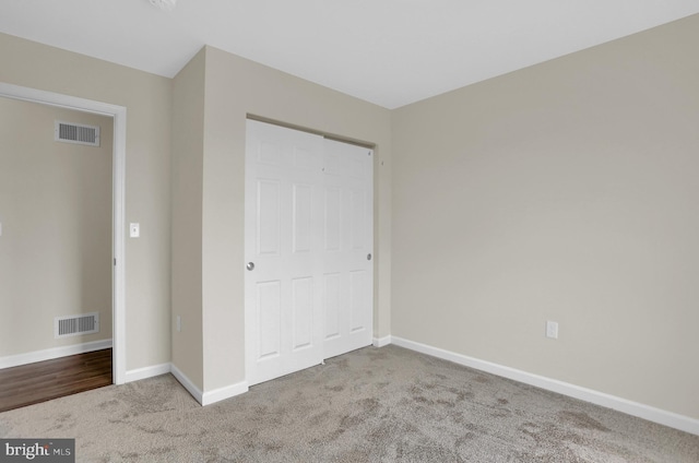 unfurnished bedroom featuring a closet and light carpet