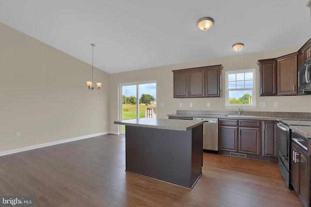 kitchen featuring sink, dark hardwood / wood-style flooring, a center island, stainless steel appliances, and dark brown cabinets