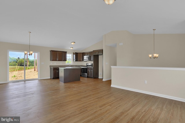 kitchen featuring decorative light fixtures, dark brown cabinets, stainless steel appliances, and a chandelier