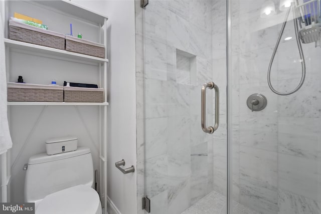 bathroom with toilet and a shower with shower door