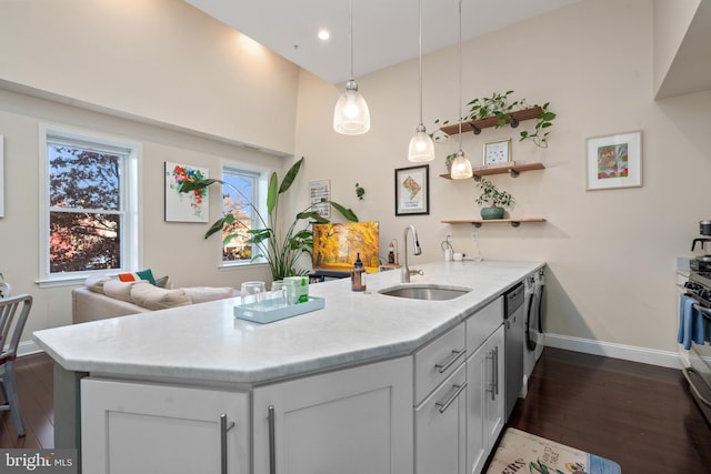 kitchen featuring white cabinetry, sink, decorative light fixtures, and kitchen peninsula