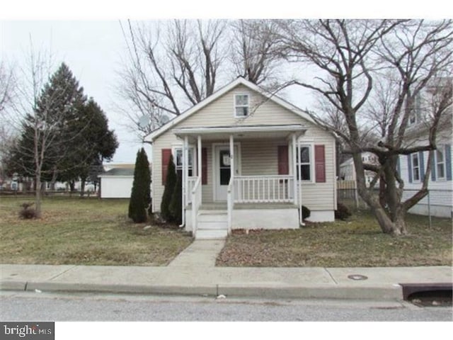 bungalow-style home featuring covered porch and a front yard