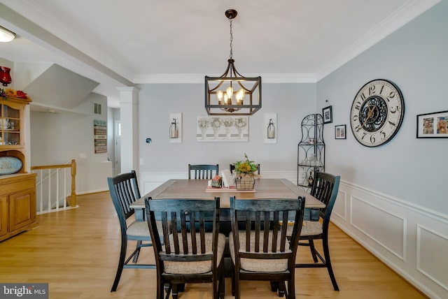 dining space with ornamental molding, light hardwood / wood-style floors, and a chandelier