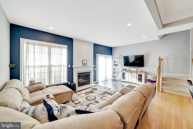 living room featuring a wealth of natural light, a fireplace, and light hardwood / wood-style floors